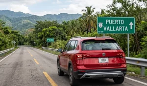 Auto rojo 2026 recorriendo una carretera de Jalisco rumbo a Puerto Vallarta durante un viaje One-Way