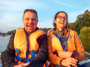 Imagen de padre e hija en un bote en medio de un lago riendo y disfrutando