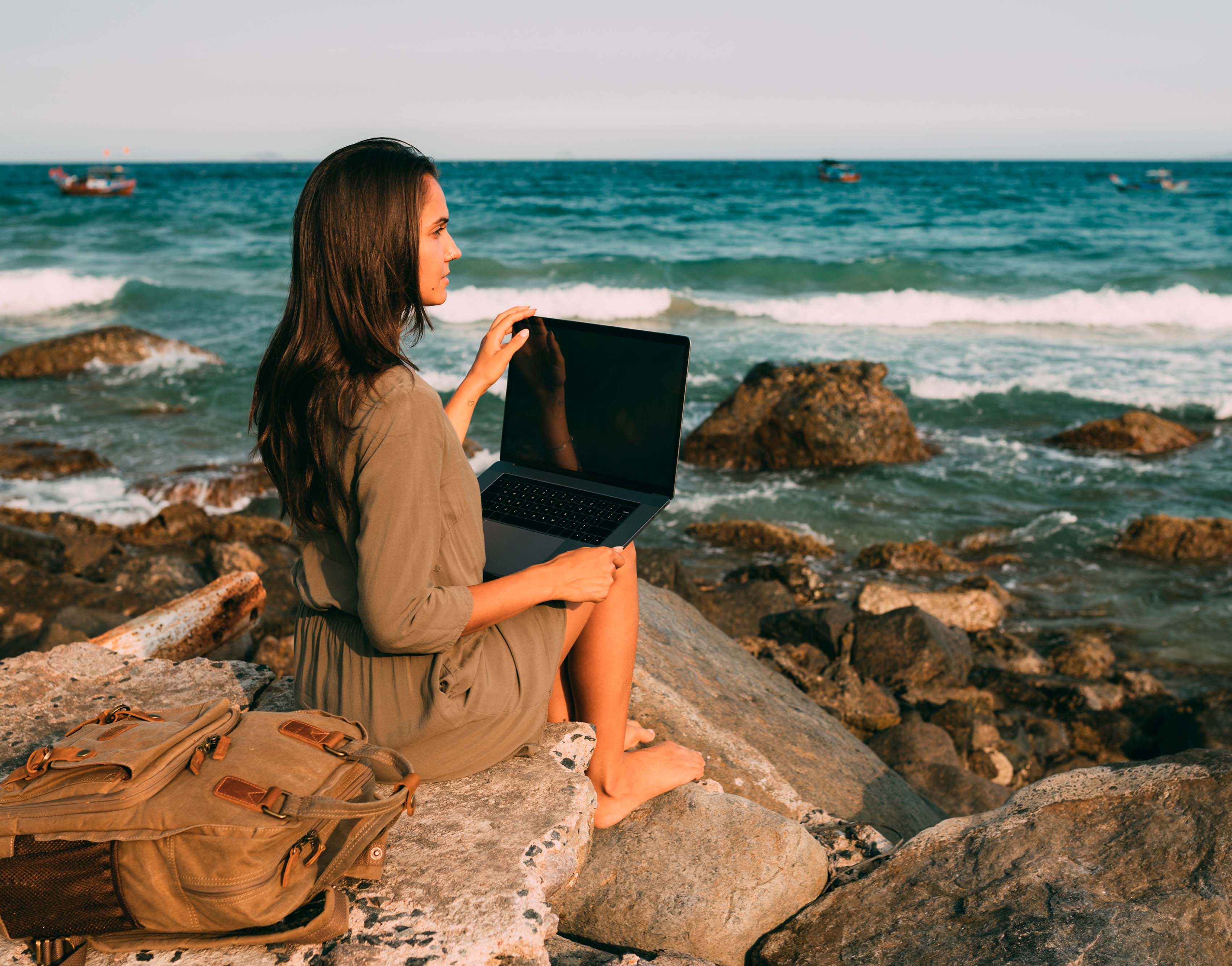 Imagen de un una mujer descalza en la playa haciendo Travel Office