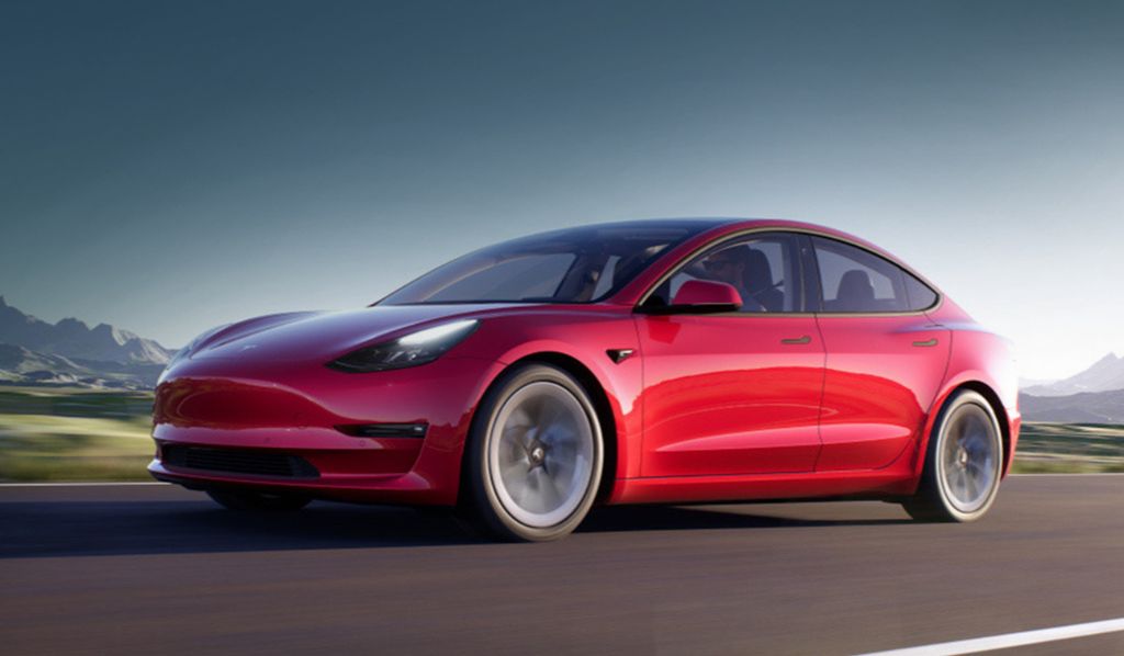 Imagen del auto eléctrico Tesla Model 3 color rojo a alta velocidad en una carretera
