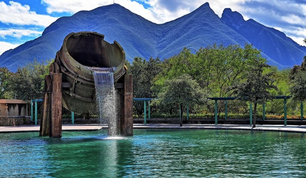 Imagen del Parque Fundidora en Nuevo León, con detalle a ex fundidora de metal que ahora funciona como fuente y de fondo la Sierra Madre