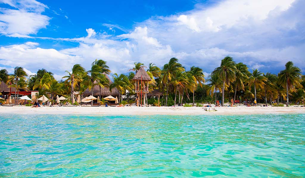 Playa mexicana con aguas turquesas y palapas a la orilla