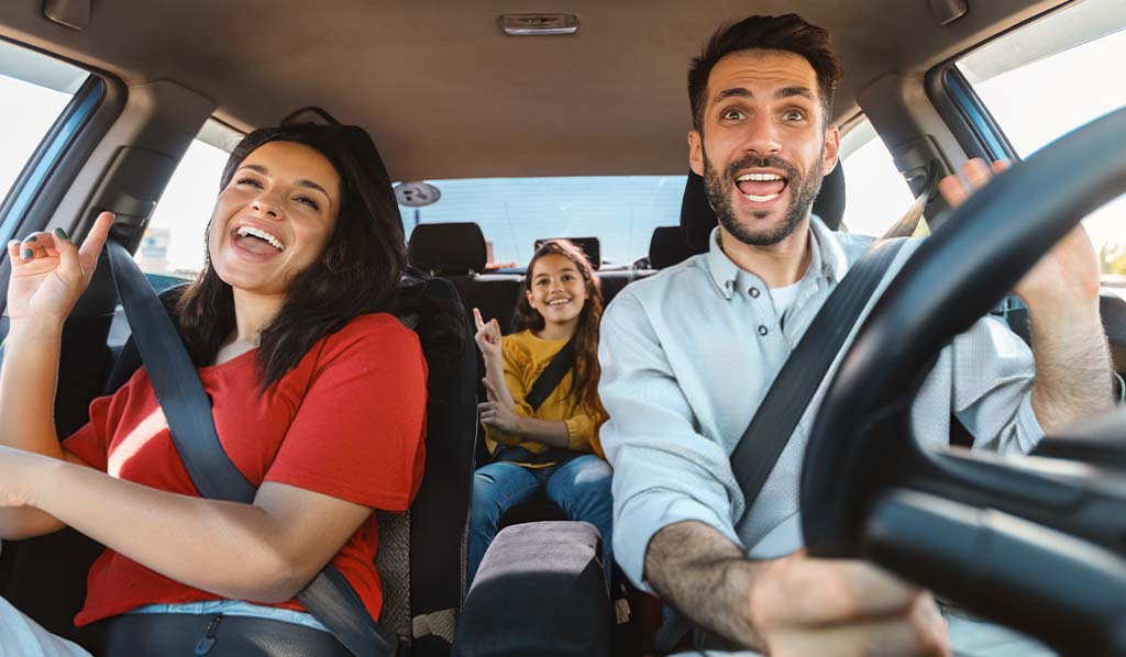 Familia feliz de tres conductores en su automóvil, bailando música y cantando canciones favoritas.
