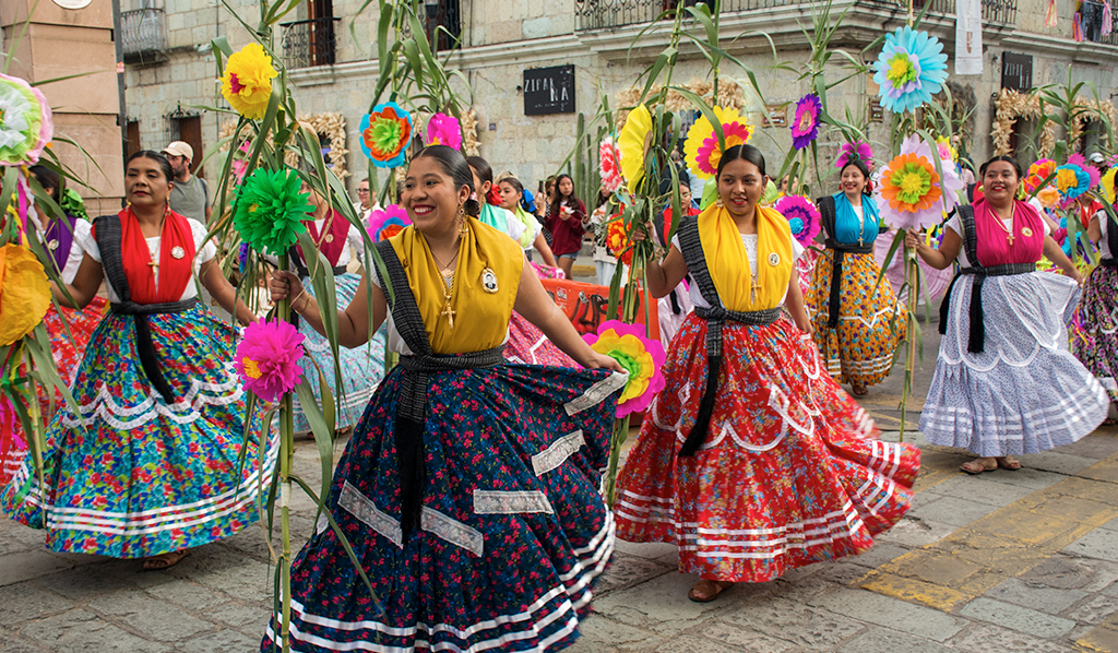 Mujeres con atuendo tradicional bailando en una ceremonia en el centro de Oaxaca