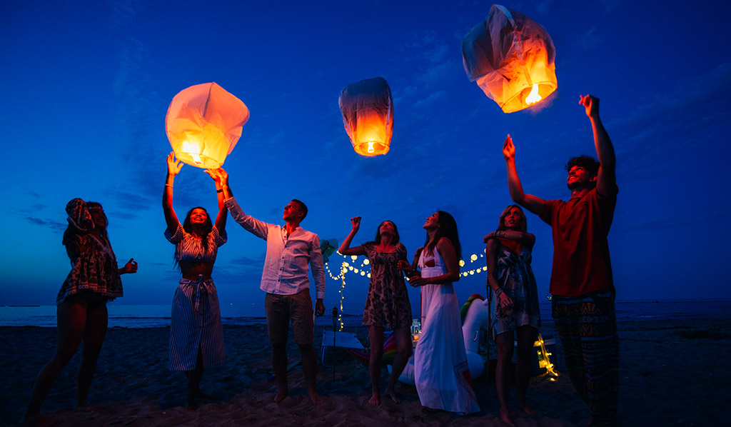 Grupo de amigos haciendo fiesta en la playa al atardecer