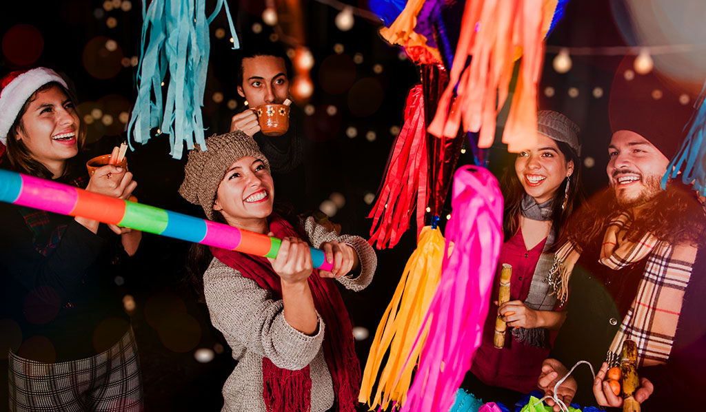 Posada Mexicana, amigos mexicanos rompiendo una Piñata y celebrando Navidad en México