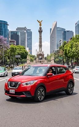 Un SUV Nissan Kicks de color rojo brillante de Avis México recorre la Zona Rosa de Ciudad de México junto al Ángel de la Independencia.