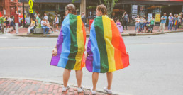 Pareja con banderas del orgullo gay.