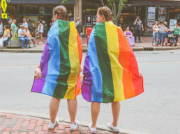 Pareja con banderas del orgullo gay.