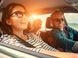 Familia viajando en auto felices al atardecer