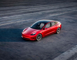 Automóvil Tesla rojo en autopista