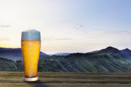 Cerveza artesanal clara en un paisaje con montañas