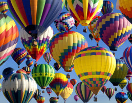Vista de varios globos aerostáticos de diversos colores en el cielo