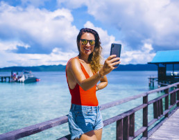 mujer alegre tomando fotos a través de una aplicación móvild, tips para tomar fotos